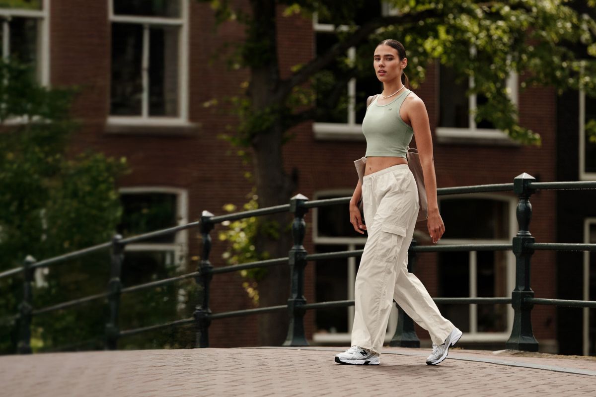 Mujer caminando con deportivas de estilo retro en un look urbano, tendencia otoño invierno 2025